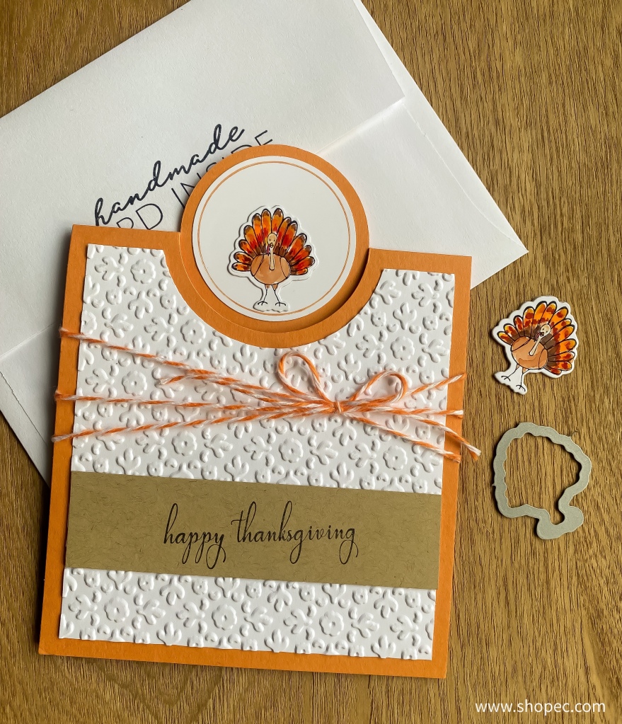 Front of handmade Thanksgiving card with small turkey at top and below is white floral paper and phrase "happy thanksgiving".